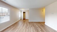 Located at 1102 W Poinsett St in Greer, South Carolina, this single-story home offers a clean, updated interior designed for comfortable living. Throughout the space, light wood-look luxury vinyl plank flooring provides a cohesive and easy-to-maintain foundation, complemented by neutral warm-beige walls and crisp white trim and baseboards. Textured ceilings add a classic touch to each room.

The open living area is bright and welcoming, featuring a front entry door with a modern hardware finish and windows fitted with horizontal blinds that allow natural light to filter in. The kitchen is outfitted with white shaker-style cabinetry accented by matte black hardware, gray laminate countertops, a stainless steel refrigerator, and a dishwasher, offering a functional and contemporary workspace.

The bedrooms are generously sized, each with windows providing natural light and outdoor views. Closet storage is well-represented, with at least one bedroom featuring a spacious reach-in closet with louvered bifold doors and a full-width hanging rod. Flush-mount light fixtures provide consistent illumination throughout.

The bathroom is finished with a full tub-and-shower combination unit, a sleek matte black fixture package including the faucet, showerhead, and towel bars, paired with gray countertops for a modern, coordinated aesthetic.