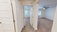 Located at 207 E Mountcastle Dr in Johnson City, Tennessee, this single-floor unit offers a thoughtfully updated interior with a clean, neutral palette throughout. The kitchen is a standout feature, showcasing rich gray-toned cabinetry with brushed nickel hardware, light quartz countertops, a subway tile backsplash, a stainless steel sink, and a full suite of stainless steel appliances including a refrigerator, electric range, built-in microwave, and dishwasher. Light wood-look flooring runs through the kitchen area, transitioning to plush wall-to-wall carpet in the living and sleeping areas. The spacious main living area benefits from natural light streaming through large windows fitted with blinds, and a ceiling fan enhances comfort overhead. A sliding barn-style door adds a modern architectural touch and leads conveniently toward the kitchen. The bedroom is generously sized, featuring its own ceiling fan, a wall-unit HVAC system beneath the window, and a closet with built-in shelving. The full bathroom is finished with warm wood-toned cabinetry, light hardwood-style flooring, recessed lighting, and a full tub-shower combination with clean white tile surround. Safety features including smoke and alarm devices are present throughout.
