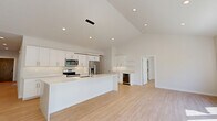 Located at 20655 Royalton Rd in Strongsville, Ohio, this modern two-story home offers a thoughtfully designed layout spread across two well-proportioned floors. The main level features an expansive open-concept kitchen and living area highlighted by striking vaulted ceilings and recessed lighting. The kitchen is outfitted with white shaker cabinetry, quartz countertops, stainless steel appliances, a large center island with pendant lighting, and a built-in wine refrigerator — ideal for both everyday living and entertaining. Light hardwood flooring flows seamlessly throughout both levels, enhancing the home's clean, contemporary aesthetic. The upper floor houses the two bedrooms, including a generously sized primary bedroom with large black-framed windows that invite abundant natural light and neighborhood views. The primary suite includes a custom walk-in closet with built-in shelving, hanging rods, and drawers. Four well-appointed bathrooms feature white cabinetry, quartz countertops, large-format gray tile flooring, and tub-shower combinations with subway tile surrounds. A dedicated laundry room with full-size washer and dryer hookups adds everyday convenience. Bright, neutral-toned hallways connect the home's spaces with ease, completing this move-in-ready residence.