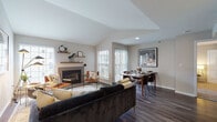 Located at 100 Morgan St in Stamford, Connecticut, this thoughtfully designed single-floor residence offers a blend of modern finishes and comfortable living across a well-appointed floor plan. The open-concept living and dining area serves as the heart of the home, highlighted by soaring vaulted ceilings that amplify the sense of space and light. A tile-surround fireplace with floating wood shelving anchors the living area, while large windows flood the room with natural light and provide views to the outdoors. Dark hardwood-style flooring extends throughout the main living spaces, adding warmth and contrast to the neutral palette. The dining area sits adjacent to the living room, with sliding glass door access to a private outdoor balcony. The kitchen features stainless steel appliances, including a gas range and over-range microwave, paired with white quartz countertops, a classic subway tile backsplash, and two-tone cabinetry. Both bedrooms offer plush carpeting, ceiling fans, and generous closet space, with the primary bedroom featuring its own sliding door access to an outdoor area. Each bathroom is finished with white subway tile surrounds, granite-style countertops, white cabinetry, and soaking tubs. The overall ambiance is modern, airy, and inviting throughout.