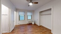 Located at 1936 N Clark Street in Chicago's vibrant Lincoln Park neighborhood, this compact one-bedroom, one-bathroom unit offers a practical and well-organized layout across a single floor. The bedroom serves as the primary living space and features warm hardwood-style flooring, crisp white walls, and a ceiling fan with integrated lighting. Two windows allow natural light to fill the room, complemented by a classic cast-iron radiator for heating. An open built-in closet with shelving provides convenient storage. The bathroom is finished with neutral stone-look tile flooring and white subway tile surrounding a full bathtub and shower combination, giving it a clean and timeless appearance. The unit also includes a kitchen and an additional closet, maximizing functionality within the compact footprint. Crown molding details throughout add a subtle architectural character consistent with the building's classic Chicago style. The layout is efficient and straightforward, making excellent use of the available space. Situated along N Clark Street, the unit benefits from proximity to Lincoln Park's wide array of dining, retail, and transit options, placing residents in the heart of one of Chicago's most sought-after neighborhoods.