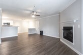 Located at 400 Eden Roc Cir in Virginia Beach, Virginia, this single-floor residence offers a well-designed layout with a cohesive blend of comfort and functionality. The open living area is a standout feature, showcasing rich hardwood-style flooring, crown molding, and a ceiling fan with light fixture. A classic fireplace anchors one wall, while French doors invite natural light and provide access to the outdoors. The living space flows seamlessly toward the kitchen, which is outfitted with white cabinetry, granite-style countertops, stainless steel appliances including a refrigerator, range, and built-in microwave, and continued hardwood-style flooring — giving it a clean, modern aesthetic. The bedrooms are generously sized, featuring plush wall-to-wall carpeting, neutral gray walls, and ample natural light. One bedroom includes access to a walk-in closet and an adjoining bathroom. The bathroom is equipped with a full soaking tub and shower combination with brushed nickel fixtures and hardwood-style flooring. Throughout the home, neutral tones, clean lines, and consistent finishes create a bright, welcoming ambiance well-suited for comfortable everyday living in Virginia Beach.