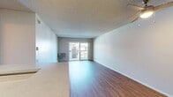 This contemporary 1-bedroom apartment in Newport Beach offers 600 square feet of efficiently designed living space. The heart of the home is a sleek, galley-style kitchen featuring modern appliances, ample counter space, and wood-tone cabinetry. The living area is bright and airy, with wood-look flooring and sliding glass doors that lead to a private balcony, perfect for enjoying the coastal climate. The bedroom, measuring 170 square feet, includes a mirrored closet door, maximizing space and light. The bathroom showcases a large vanity with contemporary fixtures and bright lighting. Throughout the apartment, neutral tones and clean lines create a fresh, modern aesthetic. Additional amenities include in-unit climate control and updated lighting fixtures. The open floor plan and thoughtful design make this compact space feel spacious and inviting, ideal for comfortable coastal living.