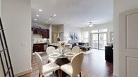 Located at 770 N Eldridge Pkwy in Houston, Texas, this thoughtfully designed two-bedroom, two-bathroom residence offers a well-appointed single-floor layout. The open-concept living, dining, and kitchen area forms the heart of the home, unified by rich hardwood-style flooring and an abundance of natural light. The kitchen is a standout feature, showcasing dark espresso cabinetry, granite countertops, a stone tile backsplash, stainless steel appliances, and a central island with bar seating — ideal for both cooking and casual dining. A glass-top dining table sits adjacent, flowing seamlessly into the living room, which opens to a private balcony through sliding glass doors. The living area is finished with a ceiling fan and ample wall space. The primary bedroom offers generous proportions, plush carpeting, and direct access to an en-suite bathroom featuring a dual-sink vanity with granite counters and a soaking tub. The second bedroom is bright and comfortable, benefiting from large windows. The second bathroom also includes a soaking tub and granite vanity. Two dedicated closets provide practical storage throughout.