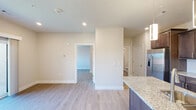 Located at 1500 SW Aileron Cir in Bentonville, Arkansas, this thoughtfully designed one-bedroom, one-bathroom residence offers a cohesive modern aesthetic across its single-floor layout. Light wood-style flooring runs throughout, providing a clean and consistent foundation that brightens each room.

The kitchen serves as the centerpiece of the living area and is outfitted with rich dark-stained cabinetry, granite countertops, a subway tile backsplash, and a full suite of stainless steel appliances including a range, microwave, and refrigerator. A kitchen island with pendant lighting overhead and an undermount sink adds both functionality and style, making it ideal for cooking and casual dining.

The open layout connects the kitchen seamlessly to the main living area, which benefits from recessed lighting and a clean, neutral color palette. The bedroom is a comfortable and well-proportioned retreat featuring a ceiling fan, built-in shelving, and a window that invites natural light and outside views. A dedicated closet provides convenient storage.

The bathroom is clean and functional, featuring a shower/tub combination with tile surround and modern fixtures. Throughout the space, white panel doors, crisp trim work, and neutral walls contribute to a fresh, contemporary feel that is move-in ready.