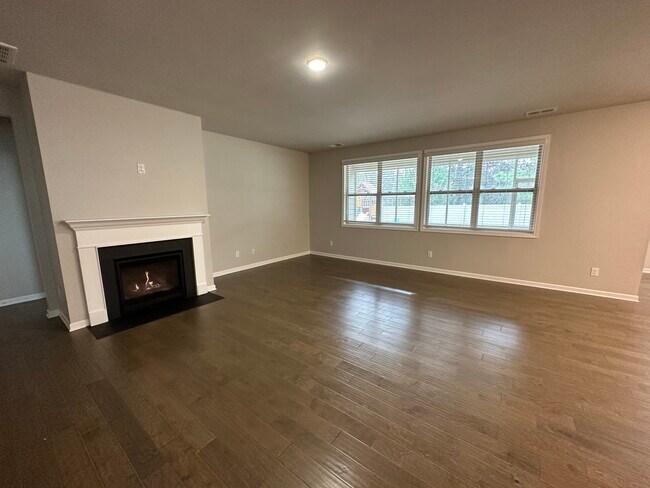 Large living room with hardwood floors and a gas fireplace! - 6425 Hickory Bell Dr