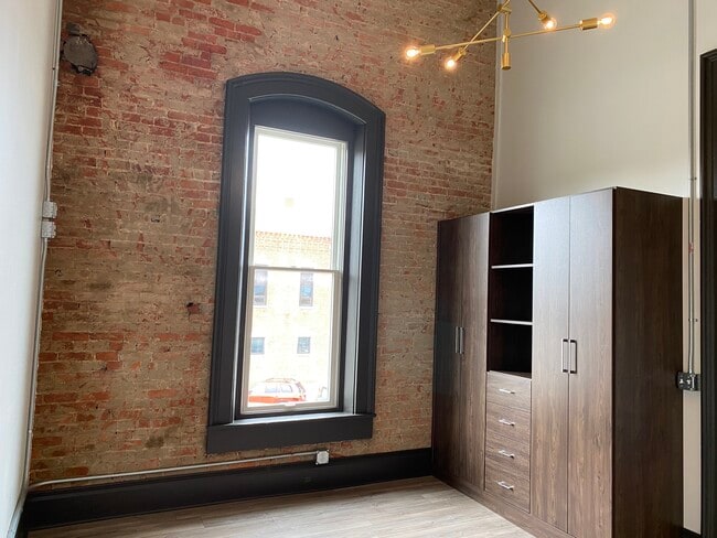 Bedroom with custom wardrobe and brick wall - 102 S Main St