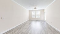 Located at Brightman Boulevard in Jacksonville, Florida, this thoughtfully designed one-bedroom, one-bathroom residence offers a comfortable and modern living experience across a single floor. Light-toned luxury vinyl plank flooring flows throughout the main living areas, complemented by neutral walls and crown molding that add a refined touch.

The kitchen is a standout feature, showcasing rich dark-wood cabinetry, granite countertops, a large central island with an undermount sink, pendant lighting, and a full suite of stainless steel appliances. A dedicated in-unit laundry room with a Samsung washer and dryer is conveniently accessible directly from the kitchen.

The spacious living area is bathed in natural light through large windows and is finished with a ceiling fan overhead, creating a bright and airy atmosphere. The generously sized bedroom features plush wall-to-wall carpeting, a ceiling fan, a natural-light window, and a walk-in closet with built-in shelving for ample storage.

The bathroom is elegantly appointed with granite-topped dark wood vanity, wood-look flooring, and a soaking tub with a curved shower rod framed by marble-style tile surround. Crown molding and consistent finishes throughout tie the entire space together with a cohesive, polished aesthetic.