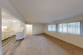 Located at 3620 Windmill Dr in Waterford, MI, this single-floor, one-bedroom, one-bathroom unit offers a practical and well-organized layout. The open living room serves as the heart of the home, featuring neutral wall-to-wall carpeting, bright white walls, and a large window dressed with vertical blinds that allows abundant natural light to fill the space. The room provides a generous, open feel well-suited for comfortable living and entertaining. Adjacent to the living area is the combined dining and kitchen space, where wood-style flooring transitions from the carpeted zones. The galley-style kitchen is equipped with ample upper and lower cabinetry in a warm neutral tone, laminate countertops, a stainless steel sink, and white appliances including a range, dishwasher, and refrigerator — providing efficient use of the available space. The bedroom is a comfortable, carpeted retreat featuring a window with vertical blinds for natural light and privacy, a ceiling light fixture, and easy access to the hallway. The full bathroom includes a white vanity with storage, a toilet, and a tub/shower combination with white tile surround and accessible grab bars. Notably, the unit includes four closets throughout, offering exceptional storage capacity for a home of this size.