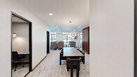Located on Roxborough Road in Charlotte's 28211 corridor, this refined professional suite delivers a thoughtfully curated workspace across a single floor. The layout encompasses a welcoming entrance, a hallway connecting key areas, a spacious conference room, a collaborative lounge, a dedicated office, two bathrooms, and one additional flex room.

The conference room is a standout feature, showcasing a large oval table surrounded by cognac leather chairs, a wood-paneled ceiling with integrated ambient lighting, a wall-mounted display screen, and sleek black-framed glass partitions that maintain visual connectivity with the rest of the suite.

The lounge area offers a bright, open atmosphere with oversized black-framed windows framing lush outdoor greenery. Modular seating in neutral tones is arranged around low tables, creating an inviting setting for informal collaboration or relaxation.

The private office spaces feature built-in stone-surface desks with striking veined marble finishes, geometric-patterned wallcovering, and brass-accented task lighting—offering a focused and elegant environment for individual work.

Throughout, the suite is unified by textured stone-patterned carpeting, warm wood accents including a striking fluted walnut partition wall, crisp white walls, and contemporary pendant lighting, resulting in a cohesive, upscale professional ambiance.
