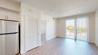 Located at 3518 Chesapeake Ave in Los Angeles, CA 90016, this well-designed one-bedroom, one-bathroom unit offers a clean, contemporary aesthetic throughout. Light-toned wood-style flooring flows seamlessly across the entire floor plan, creating a cohesive and bright atmosphere.

The open-concept kitchen and living area serves as the heart of the unit. The kitchen is outfitted with white shaker-style cabinetry, dark countertops, and a full suite of stainless steel appliances, including a refrigerator, range, microwave, and dishwasher. Recessed lighting illuminates the space efficiently.

The living area is open and inviting, with a sliding glass door leading to a private balcony that overlooks the surrounding neighborhood, bringing in abundant natural light and outdoor views of the tree-lined surroundings.

The bedroom is a comfortable, well-proportioned retreat featuring a large window with vertical blinds that frame views of the neighborhood greenery. A dedicated closet provides practical storage. The clean white walls and light flooring keep the room feeling airy and bright.

The bathroom includes a white vanity with dark countertops, a large mirror, and a shower-tub combination, maintaining the same modern, clean design language found throughout the unit. Overall, the space presents a fresh, move-in-ready environment with a minimalist modern character.