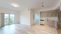 Located at 2480 NW 48th St in Miami, FL, this well-designed 2-bedroom, 1-bathroom residence offers a clean, modern aesthetic throughout. Light-toned wood-style flooring runs seamlessly across the entire unit, creating a bright and cohesive feel. The open kitchen is a standout feature, outfitted with light wood cabinetry, stainless steel appliances including a refrigerator, electric range, built-in microwave, and dishwasher, all complemented by light countertops and a neutral color palette. The living area benefits from access to a private balcony through sliding glass doors, offering views of the surrounding Miami landscape and open sky. Both bedrooms are finished with the same light flooring and crisp white walls, with windows that invite natural light and neighborhood views. The primary bedroom includes a built-in closet with double doors for added storage. A hallway connects the rooms efficiently, maintaining an organized layout. The bathroom features wood-look tile flooring, a vanity with warm wood cabinetry, and a full tub and shower enclosed with elegant marble-style wall tiles. The overall ambiance is fresh, clean, and contemporary, well-suited for modern urban living in Miami.