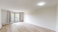 Located at 360 Falshire Drive NE in Calgary, AB, this well-appointed 3-bedroom unit offers a functional and comfortable single-floor layout. The open living area is finished with light wood laminate flooring that runs throughout, creating a bright and cohesive feel. Crisp white walls and neutral tones contribute to an airy, clean ambiance across all rooms.

The galley-style kitchen is thoughtfully updated with white cabinetry featuring black hardware accents, stone-look countertops, a classic white subway tile backsplash, and a stainless steel dishwasher. A range hood and track lighting provide practical illumination for meal preparation.

The spacious primary bedroom offers generous proportions and features a full-width mirrored sliding closet, maximizing both storage and the sense of space. The two additional bedrooms are similarly finished with light flooring and mirrored sliding closets, each benefiting from windows that frame outdoor greenery views and allow ample natural light to filter through.

Baseboard heating is present throughout the unit, ensuring efficient warmth during Calgary's colder months. The living area opens to a private balcony through a large sliding glass door, offering pleasant outdoor views of the surrounding neighbourhood. The textured ceilings in select rooms add subtle character to the overall design.