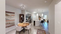 Located at 1421 Legacy Falls Dr in Wake Forest, NC, this single-floor, 2-bedroom, 2-bathroom residence offers a thoughtfully designed layout with modern finishes throughout. The open-concept kitchen and living area serves as the heart of the home, featuring dark espresso cabinetry extending to the ceiling, stainless steel appliances including a French door refrigerator, electric range, and built-in microwave, all complemented by light quartz countertops and a peninsula with an undermount sink. Pendant lighting and light wood-style flooring enhance the contemporary aesthetic. The living room is bright and inviting, with large windows that bring in natural light and provide views of the outdoors, along with a ceiling fan for year-round comfort. Both bedrooms are carpeted and generously sized, each equipped with ceiling fans. The primary bedroom connects to a dual-sink en-suite bathroom featuring dark wood vanity cabinetry, a wide mirror, and direct access to a walk-in closet. The second bathroom offers a full soaking tub and shower combination with tile flooring. With three closets and a dedicated hallway, storage and flow are well-considered throughout this stylish and functional residence.