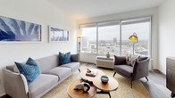 Located at 50 Morgan in Hartford, Connecticut, this single-floor residence offers a thoughtfully designed layout that blends contemporary style with functional living. The open-concept living area is bathed in natural light from expansive floor-to-ceiling windows, framing impressive panoramic views of the Hartford skyline—a standout feature that defines the ambiance of the entire space. The living room features warm hardwood-style flooring, clean white walls, and ample space for comfortable seating arrangements. The kitchen is well-appointed with dark shaker-style cabinetry, granite countertops, and a full suite of stainless steel appliances, including a refrigerator, range, microwave, and dishwasher. An in-unit washer is also present, adding everyday convenience. The bedroom is generously sized, also benefiting from large windows with sweeping city views, and includes hardwood-style flooring that carries throughout the unit. The bathroom is finished with matching dark cabinetry, a granite-topped vanity, and hardwood-style tile flooring, maintaining a cohesive aesthetic. Throughout the residence, a neutral color palette, modern fixtures, and consistent finishes create a clean, contemporary atmosphere well-suited for urban living in downtown Hartford.
