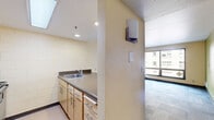 Located at 1705 SW 11th Ave in Portland, Oregon, this one-bedroom, one-bathroom unit offers a functional and efficiently designed single-floor layout. The open living area makes a visual impact with a bold chartreuse accent wall, patterned carpet flooring in blue-grey tones, and a connected kitchen featuring a breakfast bar counter, cabinetry, and a stainless steel refrigerator — all contributing to a practical yet characterful living space.

The bedroom is a well-proportioned, carpeted room that receives natural light through a street-facing window with curtains, offering views of the surrounding Portland cityscape. A built-in open closet with a hanging rod provides convenient storage directly within the room, complemented by warm-toned wood detailing on the entry door.

The bathroom is clean and straightforward, featuring a full-size soaking tub with an overhead shower, white surround panels, and chrome fixtures. A yellow accent ceiling adds a pop of color to the space.

A hallway connects the main living areas, providing a clear and logical flow throughout the unit. The tile-to-carpet transitions are clean, and the overall layout is compact yet complete — making this an informative, move-in-ready unit well-suited to those seeking efficient urban living in Southwest Portland.