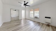 This 260 square foot apartment in Los Angeles offers a thoughtfully designed living space that maximizes functionality in a compact footprint. The single-floor layout comprises one bedroom, one bathroom, and a kitchen, efficiently arranged to create a comfortable urban dwelling.

The living area features light-toned wood-look flooring that extends throughout the space, creating a sense of continuity and openness. Large windows allow ample natural light to flood the room, enhanced by the crisp white walls. A modern ceiling fan with sleek blades adds both style and comfort.

The kitchen, though compact, boasts a contemporary design with contrasting elements. White cabinetry is offset by a striking navy blue subway tile backsplash, creating a bold visual impact. Stainless steel appliances and a undermount sink complete the modern aesthetic.

The bathroom showcases a clean, minimalist design with white tiled walls and a shower/tub combination. A window in the bathroom provides natural light and ventilation.

The bedroom, measuring 180 square feet, offers a generous space for rest and relaxation. It features the same wood-look flooring and is equipped with a modern ceiling fan, ensuring comfort in the Los Angeles climate.

Throughout the apartment, careful attention to detail is evident in the choice of materials and finishes, creating a cohesive and contemporary living environment. Despite its modest size, this apartment efficiently utilizes every square foot to provide a functional and stylish urban home.