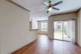 Located in the vibrant Montrose neighborhood of Houston, TX, this 2-bedroom, 2-bathroom single-floor residence offers a thoughtfully designed layout with quality finishes throughout. The open living and dining area is anchored by warm hardwood-style flooring, crown molding, and a ceiling fan, creating a bright and comfortable atmosphere. Large sliding glass doors lead to a private patio enclosed by wrought-iron railings, offering views of lush landscaped greenery. The kitchen is a functional highlight, featuring a granite-topped island with a breakfast bar overhang, dark cabinetry, stainless steel appliances — including a gas range and microwave — and track lighting overhead. The spacious primary bedroom includes plush carpeting, a ceiling fan, and access to a generous walk-in closet outfitted with multi-level wire shelving. The second bedroom is equally comfortable with carpet flooring and natural light from a window. Both bathrooms are clean and well-finished, with one featuring a full soaking tub and shower combo with tiled surround and hardwood-style flooring. Additional conveniences include multiple closets, dedicated laundry space, and two hallways connecting the home's functional zones seamlessly.