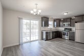 Located at 1 E Franklin St in New Freedom, PA, this three-story home offers a well-organized layout across multiple levels, finished with a consistent and clean design throughout. The main living level features durable hardwood-style flooring and an open-concept kitchen and dining area. The kitchen is equipped with rich, dark cabinetry, granite countertops, stainless steel appliances including a range, built-in microwave, and dishwasher, complemented by pendant lighting and a sliding glass door that opens to an outdoor deck with natural views. A half bathroom with hardwood-style flooring is also conveniently located on this level. The entry level provides a welcoming foyer with hardwood-style floors, a front door with glass accents, and a carpeted staircase with dark wood railings leading to the upper floors. The upper level hosts carpeted bedrooms filled with natural light from large windows, including a ceiling fan fixture. A full bathroom with a soaking tub and shower combination serves this floor, while an additional bathroom features a walk-in shower stall. A utility room with closet storage and laundry connections rounds out the upper level. Throughout the home, neutral tones, clean lines, and consistent finishes create a bright and functional living environment.