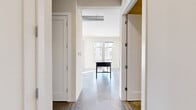 Located on N Commerce Street in Milwaukee, WI, this well-designed one-bedroom, one-bathroom unit offers a thoughtful layout across a single floor. The entrance opens into a corridor flanked by two closets, providing ample storage before leading into the main living area. Polished concrete floors run throughout the unit, lending an industrial-modern aesthetic that ties the spaces together cohesively. The combined kitchen and living room forms the heart of the home, bathed in natural light from tall windows and a sliding glass door. The kitchen is well-appointed with white shaker cabinetry, granite-look countertops, stainless steel appliances including a range, microwave, refrigerator, and dishwasher, and a central island that doubles as a prep and dining surface. Exposed ductwork along the ceiling adds an urban loft character to the space. The living area flows directly to a private balcony offering open views of the building's courtyard and the surrounding Milwaukee cityscape. The bedroom is a comfortable, dedicated space, while the bathroom features a full tub-shower combination. Recessed lighting throughout ensures a bright, clean atmosphere, making this unit a functional and stylish urban residence.