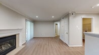 Located at 100 Calibre Brooke Way in Smyrna, GA, this one-bedroom, one-bathroom unit offers a well-organized single-floor layout designed for comfortable everyday living. The combined kitchen and living room serves as the heart of the home, where light wood-style laminate flooring, crown molding, and recessed lighting create a clean, cohesive aesthetic. The living area is anchored by a classic fireplace with a white-painted mantel and tile surround, complemented by a window that brings in natural light. The kitchen features warm honey-toned wood cabinetry, stainless steel appliances including a gas range and refrigerator, white countertops, and a peninsula that provides additional prep and serving space. The bedroom is finished with plush carpeting, a ceiling fan, and a window with views of surrounding greenery, offering a calm and private retreat. A dedicated walk-in closet provides generous storage. The full bathroom includes a tiled tub and shower combination with clean white tile surround. Additional utility and hallway spaces round out the practical layout. Neutral tones throughout the unit lend a versatile backdrop adaptable to a variety of décor styles.
