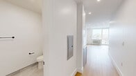 Located on the fifth floor at 337-339 Johnston Ave in Jersey City, NJ, this thoughtfully designed studio presents a clean, modern aesthetic throughout its efficiently organized single-floor layout. The open-plan kitchen and living area serves as the heart of the unit, featuring light hardwood flooring, recessed lighting, and crisp white walls that lend a bright, airy feel to the space. A large window allows generous natural light to fill the room while offering elevated views of the surrounding Jersey City neighborhood. The kitchen is well-appointed with white shaker-style cabinetry, quartz countertops, a subway tile backsplash, stainless steel appliances including a gas range with over-the-range microwave, a dishwasher, and a deep single-basin sink with a matte black faucet — all finished with sleek black hardware throughout. The bathroom showcases a contemporary design with large-format gray tile walls, porcelain tile flooring, a white vanity with quartz countertop, a framed mirror, and matte black fixtures and accessories. An in-unit laundry area adds practical convenience. The unit's neutral palette, quality finishes, and efficient layout make it a polished and functional urban residence.