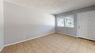 Located at 444 Florida St SE in Albuquerque, New Mexico, this one-bedroom, one-bathroom unit offers a practical and well-organized single-floor layout. The interior is finished in cool, neutral gray tones throughout, creating a clean and cohesive aesthetic.

The living room features light beige tile flooring and a large window fitted with blinds, allowing natural light to brighten the space while offering views of the surrounding greenery. The kitchen is efficiently designed with white cabinetry, granite-look countertops, a stainless steel refrigerator, and a range, complemented by a window above the sink that brings in additional daylight.

The bedroom is a comfortable size, offering warm wood-look luxury vinyl plank flooring, a window with natural light, and a sliding double-door closet providing ample storage. The textured ceiling adds a subtle architectural detail consistent throughout the unit.

The bathroom is neatly appointed with a white vanity, a medicine cabinet with mirror, brushed nickel fixtures, and tile flooring, maintaining the clean, functional character of the space.

Overall, this unit presents a tidy, move-in-ready layout well-suited for those seeking a manageable, low-maintenance living space in the Southeast Heights neighborhood of Albuquerque.