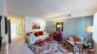 This two-floor residence in Saint Louis, Missouri offers a well-organized layout across its multiple levels. The living room serves as the heart of the home, featuring soft carpeting, a textured ceiling, and a dual-tone color scheme with cool blue-gray and crisp white walls that create a calm, inviting atmosphere. Natural light filters through vertical blinds, brightening the space throughout the day.

The kitchen is equipped with dark wood cabinetry offering ample storage, a double-basin sink, and a full suite of appliances including a refrigerator, range, and dishwasher. Light tile flooring adds a clean, practical finish. Adjacent to the kitchen, the dining area features a warm golden accent wall and tile flooring, providing a defined space for meals.

The bedrooms are carpeted and well-proportioned, each offering a cozy retreat. The primary bedroom includes room for substantial furniture and connects to additional hallway spaces. A second bedroom features neutral walls, natural light from a window, and a clean, understated design. The bathroom is finished with white tile surrounding a full tub-shower combination, maintaining a simple and functional aesthetic throughout. Overall, the home presents a practical and comfortable living environment.