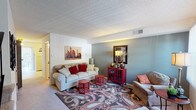 This two-floor residence in Saint Louis, Missouri offers a well-organized layout across its multiple levels. The living room serves as the heart of the home, featuring soft carpeting, a textured ceiling, and a dual-tone color scheme with cool blue-gray and crisp white walls that create a calm, inviting atmosphere. Natural light filters through vertical blinds, brightening the space throughout the day.

The kitchen is equipped with dark wood cabinetry offering ample storage, a double-basin sink, and a full suite of appliances including a refrigerator, range, and dishwasher. Light tile flooring adds a clean, practical finish. Adjacent to the kitchen, the dining area features a warm golden accent wall and tile flooring, providing a defined space for meals.

The bedrooms are carpeted and well-proportioned, each offering a cozy retreat. The primary bedroom includes room for substantial furniture and connects to additional hallway spaces. A second bedroom features neutral walls, natural light from a window, and a clean, understated design. The bathroom is finished with white tile surrounding a full tub-shower combination, maintaining a simple and functional aesthetic throughout. Overall, the home presents a practical and comfortable living environment.