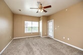 Located at 860 S 68th St in West Des Moines, Iowa, this single-floor residence offers a well-designed, open-concept layout that balances comfort and functionality. The living area is finished with plush wall-to-wall carpeting and features a ceiling fan with light fixture, along with multiple windows dressed with horizontal blinds that allow for generous natural light. A private exterior door provides convenient access directly from the living space.

The kitchen is a standout area, boasting warm-toned wood cabinetry, stone-look countertops, and a full suite of stainless steel appliances including a refrigerator, range, microwave, and dishwasher. Hard surface flooring runs throughout the kitchen, providing a practical and clean transition from the carpeted living spaces. Track lighting overhead ensures the kitchen is well-lit for cooking and entertaining.

The bedroom continues the carpeted flooring theme and is outfitted with a ceiling fan, multiple windows on adjacent walls, and ample wall space, creating a bright and airy retreat. The bathroom features tile flooring, a wood-toned vanity with an undermount sink, and a frosted window for privacy while still admitting natural light. A dedicated laundry area is also present within the unit, adding everyday convenience to this well-appointed West Des Moines residence.