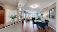 This single-floor residence offers a thoughtfully designed open-concept layout that seamlessly connects the main living areas. Rich hardwood flooring flows throughout the living and dining spaces, anchored by a spacious living room featuring crown molding, a ceiling fan, and a bold accent wall in a sophisticated blue hue that lends the room a distinctive character. Large windows invite an abundance of natural light and offer outdoor views, enhancing the room's airy ambiance.

The kitchen is well-appointed with warm cherry wood cabinetry, stainless steel appliances including a French door refrigerator, electric range, and built-in microwave, all complemented by striking granite countertops and a breakfast bar peninsula. Tile flooring completes the kitchen's practical yet refined aesthetic.

The bedrooms are generously sized and carpeted for comfort, each equipped with ceiling fans and ample closet space. The primary suite includes access to a walk-in closet with built-in shelving, while an additional bedroom benefits from bright windows with garden views.

The bathrooms are finished with tile flooring, granite vanity countertops, and framed mirrors, with one bathroom providing direct access to a spacious walk-in closet. Overall, the residence presents a cohesive, comfortable, and well-detailed living environment.