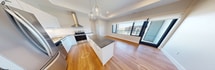 This 540-square-foot, one-bedroom, one-bathroom condo on the sixth floor at 1325 Riverbend Road offers a well-planned layout with modern finishes throughout. The open-concept living and kitchen area is anchored by a sleek kitchen featuring white flat-panel cabinetry, dark countertops, stainless steel appliances including a French door refrigerator, a tile backsplash with under-cabinet lighting, and a central island with pendant globe lighting overhead. Warm-toned hardwood flooring extends throughout the main living areas, complementing the bright, neutral palette. The 130-square-foot primary bedroom includes a tray ceiling detail and a window offering urban views of the surrounding cityscape, filling the room with natural light. A dedicated closet nook provides practical storage adjacent to the bedroom. The bathroom is elegantly appointed with large-format tile flooring, a soaker tub, and striking marble-style wall surround with brushed gold fixtures, conveying a refined, spa-like atmosphere. A welcoming entrance completes the unit. Clean lines, recessed and pendant lighting, and a cohesive modern aesthetic make this a well-appointed urban residence in London, Ontario.