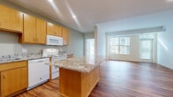 Located at 11001 Bren Road E in Minnetonka, MN, this single-floor residence offers three bedrooms, two bathrooms, a kitchen, and a living room within a thoughtfully designed layout. The open living area is bathed in natural light through large floor-to-ceiling windows, showcasing gleaming hardwood-style flooring and a clean, modern aesthetic with neutral wall tones.

The kitchen is well-equipped with warm maple cabinetry, granite countertops, a central island, and white appliances including a refrigerator, dishwasher, and range. A hallway with the same hardwood-style flooring connects the main living areas to the private quarters.

The bedrooms feature plush carpeting, generous closet space, and bright windows. The spacious primary bedroom offers a comfortable retreat with direct access to the hallway. Both bathrooms are finished with maple vanity cabinetry, white countertops, large mirrors, and hardwood-style flooring. One bathroom includes accessibility-friendly grab bars throughout.

The overall design is bright and clean, with a consistent use of warm wood tones and neutral colors creating a cohesive, welcoming atmosphere throughout the entire space.
