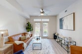 Located at 180 Jackson St NE in Atlanta's vibrant Old Fourth Ward neighborhood, this two-bedroom, two-bathroom residence offers a well-designed, single-level layout with a cohesive modern aesthetic throughout. Light wood-tone flooring runs continuously across the home, complementing the bright, neutral palette on the walls and ceilings.

The open-concept kitchen and living area serves as the heart of the home. The kitchen is outfitted with slate-gray cabinetry, quartz countertops with a marble-like finish, stainless steel appliances, and a central island with a built-in sink and dishwasher. Pendant lights with brushed nickel hardware hang above the island, adding warmth and definition to the space. The living area benefits from natural light through glass French doors and features a ceiling fan overhead.

The primary bedroom is a comfortable retreat, highlighted by a ceiling fan, a window allowing natural light, and access to a spacious walk-in closet with multi-level shelving along two walls. The second bedroom offers a versatile layout, suitable as a guest room or home office. Both bathrooms are clean and functional, with one featuring a full tub-shower combination with white tile surround. The overall ambiance is bright, cohesive, and move-in ready.