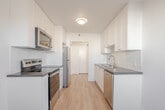 Located at 210 Fifth Ave in Kitchener, Ontario, Unit 203 is a thoughtfully designed suite offering a comfortable and functional layout across a single floor. The interior is finished with light-toned laminate hardwood flooring throughout, crisp white walls, and baseboard heating, creating a clean and cohesive aesthetic.

The galley-style kitchen is a standout feature, equipped with stainless steel appliances including a refrigerator, electric range, and over-the-range microwave. White shaker cabinetry lines both sides of the kitchen, complemented by dark countertops and a white subway tile backsplash, delivering a modern yet timeless look.

The two versatile rooms are bright and open, each benefiting from natural light streaming through windows. One room features a sliding closet door, providing practical storage. The living area offers generous open space with a passthrough to the hallway.

The bathroom is finished with classic white subway tile surrounding a full soaker tub, maintaining the unit's clean, contemporary style.

A private balcony extends the living space outdoors, offering views of the surrounding neighbourhood and ample open sky. The entry hallway provides a practical transition into the unit. Overall, this suite presents a fresh, move-in ready environment in a well-established Kitchener neighbourhood.
