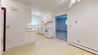 Located at 1392 Nash Rd in North Tonawanda, NY, this single-floor, 2-bedroom, 1-bathroom home offers a straightforward and functional layout with a clean, bright aesthetic throughout. The kitchen is designed in a classic galley style, featuring white cabinetry with ample upper and lower storage, light countertops, a stainless steel sink, and white appliances including an electric range, dishwasher, and refrigerator. Light tile flooring and a window with natural light enhance the kitchen's open feel, and it connects directly to the adjacent living area. The spacious primary bedroom is notably generous in size, finished with neutral carpet flooring, white walls, and two windows fitted with blinds that allow for natural light while maintaining privacy. A baseboard heating unit ensures year-round comfort. The second bedroom also features carpet flooring, white walls, and baseboard heating, providing a cozy and versatile space. The bathroom is well-appointed with a full tub and shower combination, a window for ventilation, a white vanity with storage, and clean tile flooring. Throughout the home, warm-toned wood doors with brass hardware add a consistent design detail. The overall ambiance is clean, neutral, and move-in ready.