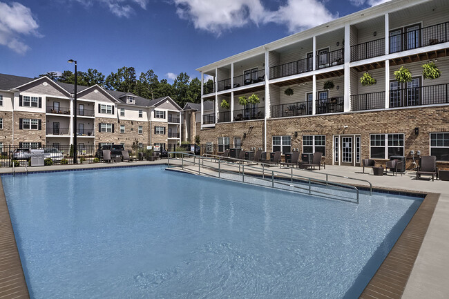 Piscina al aire libre con tumbonas en los apartamentos Retreat at the Park en alquiler en Burlington, Carolina del Norte - The Retreat at the Park