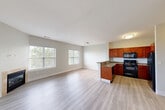 Located at 3 Windsor Woods Ln in Canton, MA, this well-appointed 2-bedroom, 2-bathroom residence offers a thoughtfully designed single-floor layout. The open-concept living and kitchen area serves as the heart of the home, where light hardwood-style flooring, neutral gray walls, and large windows with outdoor views create a bright and welcoming atmosphere. A fireplace with a tile surround anchors the living room, adding warmth and character. The kitchen is outfitted with rich cherry wood cabinetry, granite-style countertops, black appliances including a range, microwave, dishwasher, and refrigerator, and a peninsula that provides additional prep space and casual dining. Both bedrooms are carpeted and receive generous natural light through large windows overlooking greenery. The primary bedroom is a comfortable, well-sized retreat. Each bathroom features wood-toned vanity cabinetry and a tub-shower combination with light wood-style flooring. A dedicated in-unit laundry area houses a full-size washer and dryer behind bi-fold doors, adding everyday convenience. Multiple closets provide ample storage throughout, and hallways connect the spaces with an efficient, functional flow. The overall ambiance is clean, modern, and move-in ready.