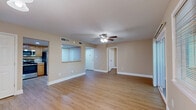 Located at 2 Hollandale Ln in Clifton Park, NY, this well-appointed single-floor home offers a thoughtfully designed layout with two bedrooms, two bathrooms, a den, and a dedicated laundry area. Warm hardwood-style flooring flows consistently throughout the home, complemented by neutral beige tones that create a bright and welcoming atmosphere.

The open-concept kitchen and living area serves as the heart of the home. The kitchen features honey-toned wood cabinetry, tile backsplash, stainless steel appliances including a dishwasher and refrigerator, and a convenient pass-through counter that connects seamlessly to the living space. The spacious living room is fitted with a ceiling fan and an elegant chandelier, and offers access to an outdoor balcony with views of surrounding greenery.

The generously sized primary bedroom includes a ceiling fan and ample closet space. The second bedroom mirrors the same warm flooring and ceiling fan fixtures. Two well-appointed bathrooms serve the home — one featuring a clean, tiled tub/shower combo, and the other equipped with a modern glass-door walk-in shower with chrome accents. An additional den provides flexible space for a home office or sitting room. With seven closets distributed throughout, storage is plentiful. The hallway connects all areas with ease, completing this functional and comfortable home.