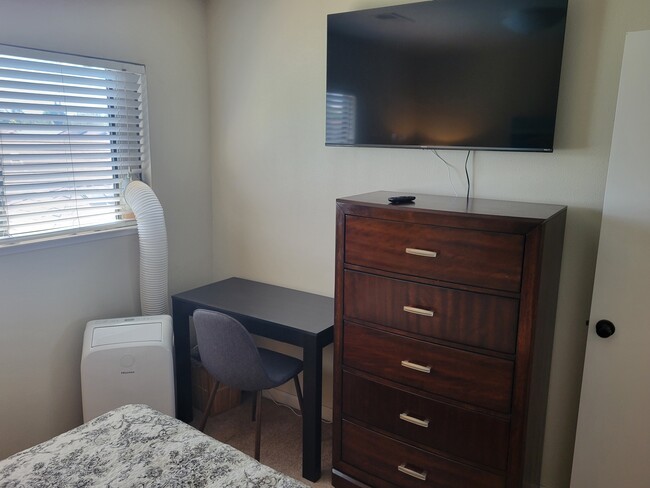 Bedroom 1 with TV, dresser, desk and AC - 5247 Grouse Run Dr