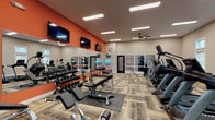 The fitness center at Ashton Park is a thoughtfully designed, single-floor facility that offers a comprehensive workout experience. The space is defined by a bold color palette, with striking orange accent walls contrasting against neutral beige tones, creating an energetic and motivating atmosphere. Patterned, wood-look carpet tiles span the floor throughout, adding texture and warmth underfoot.

The facility is divided into distinct workout zones. A dedicated free weights area features a full rack of dumbbells, kettlebells, medicine balls, and stability balls, complemented by adjustable benches and rubber exercise mats. Multiple wall-mounted flat-screen TVs and large mirrors line the walls, enhancing both entertainment and spatial awareness during training.

A separate cardio zone houses a row of treadmills, stair climbers, ellipticals, and stationary bikes, including a recumbent cycle. This section benefits from abundant natural light streaming through multiple white-trimmed windows positioned along the walls. A ceiling fan provides additional air circulation.

Strength training is further supported by a selection of cable and selectorized machines positioned throughout the space. Recessed and linear LED lighting illuminates the entire facility evenly. The overall design balances functionality with a clean, modern aesthetic, making Ashton Park's fitness center a well-rounded amenity for residents of all fitness levels.