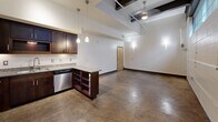 This 600 sq ft apartment blends modern design with industrial elements. The open-concept layout showcases polished concrete floors and exposed ceiling beams, creating an airy atmosphere. The kitchen boasts dark wood cabinetry, stainless steel appliances, and granite countertops, complemented by a movable island. Track lighting and pendant fixtures provide ample illumination. The spacious 160 sq ft bedroom features ample closet space with sliding doors. The bathroom offers a granite vanity and a tub-shower combination. High windows allow natural light while maintaining privacy, enhancing the unit's urban loft aesthetic.