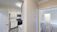 Located at 244 Kyser Blvd in Madison, Alabama, this single-floor residence offers a well-designed layout with a clean, modern aesthetic throughout. The kitchen is a standout feature, equipped with stainless steel appliances including an electric range, built-in microwave, refrigerator, and dishwasher. White shaker-style cabinetry lines the walls, complemented by granite-look countertops and a classic white subway tile backsplash. Wood-look luxury vinyl plank flooring runs throughout the kitchen and main living areas, adding warmth and durability.

The open living area is generously proportioned, with neutral-toned walls, plush carpet, and a ceiling fan that enhances comfort. The space flows naturally toward the kitchen, creating a connected and functional layout ideal for everyday living.

The bedrooms continue the neutral palette with soft carpet underfoot and ceiling fans overhead. The primary bedroom includes access to a walk-in closet and an en-suite bathroom, while additional closet space provides ample storage. The bathroom features a tub-shower combination with white tile surround, wood-look flooring, and granite-topped vanity.

Crown molding accents in select areas and textured ceilings add subtle architectural character throughout this well-appointed Madison residence.