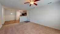 Located at 1821 Buckeye Dr in Richmond Hill, Georgia, this single-floor unit offers a thoughtfully designed layout with a blend of comfort and modern finishes throughout. The kitchen is a standout feature, equipped with a full suite of stainless steel appliances — including a refrigerator, range, and built-in microwave — complemented by rich dark cabinetry, granite-look countertops, and durable wood-look plank flooring that extends through the main living and wet areas. The open living area flows naturally from the kitchen, highlighted by a ceiling fan with light fixture overhead and plush carpeting underfoot. The primary bedroom is generously sized with its own ceiling fan, natural light from a window, and access to a spacious walk-in closet outfitted with wire shelving and hanging rods. A second carpeted bedroom features a double-door closet and dual windows that bring in ample natural light. Both bathrooms are finished with white vanities, clean countertops, and warm wood-look flooring, creating a bright and cohesive aesthetic. The overall design is clean and neutral, offering a move-in ready environment with practical storage solutions and a well-organized floor plan throughout.