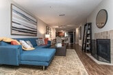 Watermark presents a well-designed single-floor residence that combines comfort and style throughout its thoughtfully arranged layout. The open-concept living room serves as the heart of the space, featuring rich hardwood-style flooring, large sliding glass doors that flood the room with natural light, and direct access to a private outdoor patio with views of surrounding greenery. The living area provides generous room for seating and entertaining, complemented by neutral wall tones that create a warm, inviting atmosphere.

The kitchen is outfitted with warm-toned wood cabinetry, granite countertops, a tiled mosaic backsplash, and black appliances. A breakfast bar with seating offers a casual dining option and connects the kitchen seamlessly to the living and dining areas.

Multiple bedrooms provide comfortable retreats, each featuring plush carpet, ceiling fans with lighting, and windows with outdoor views. Bold navy accent walls add a striking design element to the bedrooms, pairing well with the neutral tones throughout. Built-in shelving adds functional storage in select rooms.

The bathroom includes a combination tub and shower, granite vanity countertops, and wood-style flooring, offering a clean and functional design. Throughout the residence, a cohesive color palette and consistent finishes create a polished and comfortable living environment.