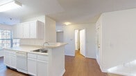Located at 426 Branchview Dr in Charlotte, NC, this single-floor residence offers a well-organized layout encompassing one bedroom, one bathroom, an exercise room, and a dedicated closet. The open-concept kitchen and living area form the heart of the home, where warm hardwood-style flooring flows throughout. The kitchen is appointed with white cabinetry extending to the ceiling for ample storage, light countertops, a peninsula with a built-in sink, and white appliances including a coil-burner range, dishwasher, and full-size refrigerator. A window at the end of the galley-style kitchen draws in natural light, keeping the space bright and functional. The spacious bedroom features plush wall-to-wall carpeting, a textured ceiling, and two windows fitted with blinds that allow for generous natural light while maintaining privacy. A built-in closet with a hanging rod provides practical storage. The bathroom includes a full soaking tub and shower combination with clean white finishes. Additional carpeted rooms offer flexible space suitable for a home gym or secondary use. Neutral tones and clean white trim throughout lend the residence a fresh, move-in-ready feel.