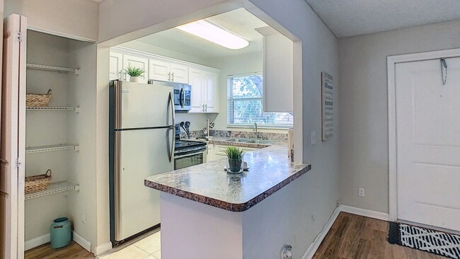 Featuring modern cabinetry, ample countertop space, stainless steel appliances, and a breakfast bar, this thoughtfully designed space makes cooking, dining, and entertaining effortless. - Boca Winds