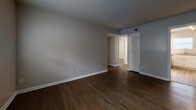 Located at 1000 Collier Rd NW in Atlanta, Georgia, this 2-bedroom, 1-bathroom single-story home offers a practical and efficient layout. Rich, dark hardwood flooring runs throughout the living room and bedrooms, lending warmth and continuity to the space, while lighter wood-tone flooring accents the kitchen and dining area.

The living room is open and unobstructed, with neutral gray walls, clean white baseboards, and a louvered closet door that adds a classic touch. A front entry door with an adjacent window allows natural light to filter into the room.

Both bedrooms feature ceiling fans with lighting, hardwood floors, and multiple windows fitted with white blinds that provide natural light while maintaining privacy. The primary bedroom includes closet access and connects to the main hallway. Altogether, the home includes four closets, offering generous storage options.

The combined kitchen and dining area is functional and well-appointed, featuring white cabinetry, granite countertops, a stainless steel refrigerator, a gas range, and a stacked washer and dryer unit—all within a compact, efficient footprint. Light wood-tone flooring and a window above the sink keep the space feeling bright.

The bathroom includes a full tub-shower combination with white tile surround and a privacy window. The home's neutral color palette and consistent finishes create a cohesive, move-in-ready feel throughout.