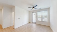 Located at 1230 Front Place in North Port, Florida, this two-bedroom, two-bathroom unit offers a well-designed single-floor layout with modern finishes throughout. Light wood-style flooring flows seamlessly across the living areas, bedrooms, and hallway, creating a bright and cohesive aesthetic.

The kitchen serves as a central highlight, featuring white shaker cabinetry with black hardware, quartz-style countertops, a herringbone tile backsplash, and a full suite of stainless steel appliances. A curved kitchen island with pendant lighting above provides additional prep space and casual seating, while also connecting the kitchen to the main living area. The living room includes a ceiling fan and access to an outdoor-facing door.

The primary bedroom is generously proportioned, appointed with a ceiling fan and natural light from a window with outdoor views. It features double doors leading to a walk-in closet equipped with multi-tiered wire shelving for organized storage. The second bedroom is clean and bright with crisp white walls.

Both bathrooms are finished with large-format neutral tile in the tub/shower surrounds and feature white cabinetry, quartz-style counters, and black hardware accents. The overall design is clean, contemporary, and well-suited for comfortable everyday living in North Port.