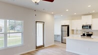 Located at 105 Bargeron Drive in Augusta, GA, this single-story, 2-bedroom, 2-bathroom home offers a clean, modern design with a bright and cohesive aesthetic throughout. The open-concept living and kitchen area serves as the heart of the home, bathed in natural light from multiple windows with blinds. A ceiling fan with a light fixture anchors the living space, which flows seamlessly onto light wood-style flooring that extends through the entire home. The kitchen is well-appointed with white shaker-style cabinetry, light quartz countertops, stainless steel appliances including a refrigerator, electric range, built-in microwave, and dishwasher, as well as a single-basin undermount sink. A back door provides convenient outdoor access directly from the living area. Both bedrooms are comfortably sized, featuring ceiling fans, large windows with outdoor views, and the same light wood-style flooring. The primary bedroom includes a walk-in closet with built-in wire shelving. Each bathroom features white vanity cabinetry with quartz countertops, updated fixtures, and wood-style flooring. Natural light is present in the bathrooms as well, with windows adding brightness to the clean, neutral palette that defines the overall ambiance of this well-maintained home.